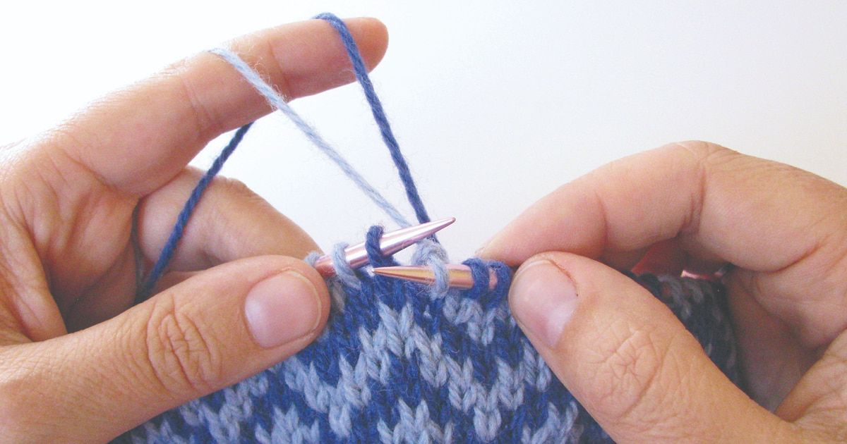Knitting stranded colorwork with two yarns held in the left hand.