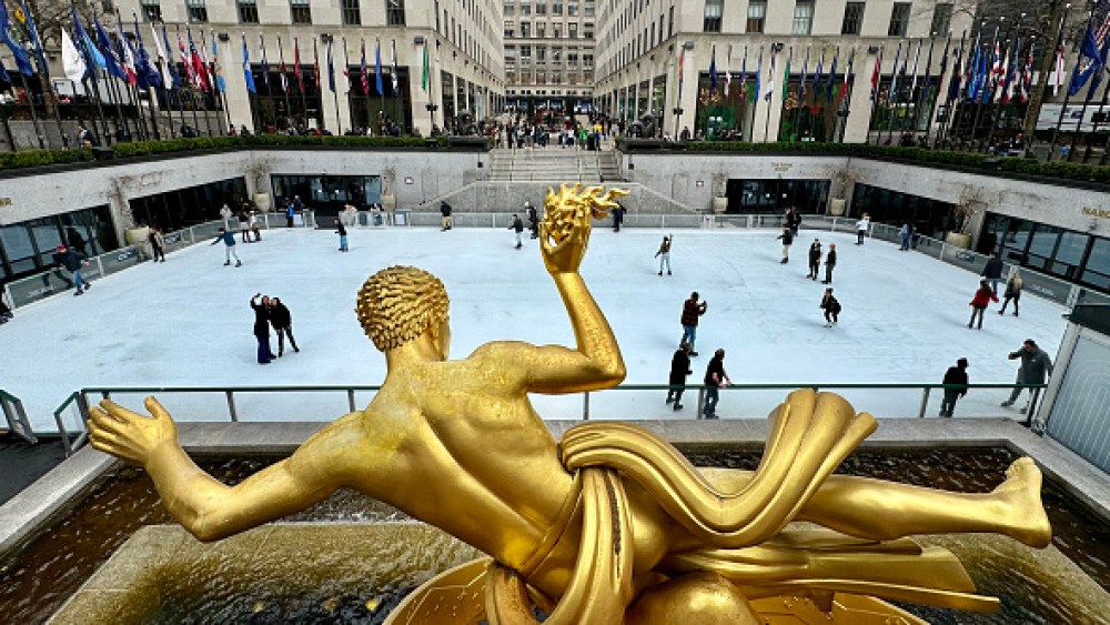 Paul Manship's gold Prometheus sculpture towers over people skating on the Rockefeller Center ice rink on March 4, 2024 in New York City. (Photo by Daniel SLIM / AFP) (Photo by DANIEL SLIM/AFP via Getty Images)
