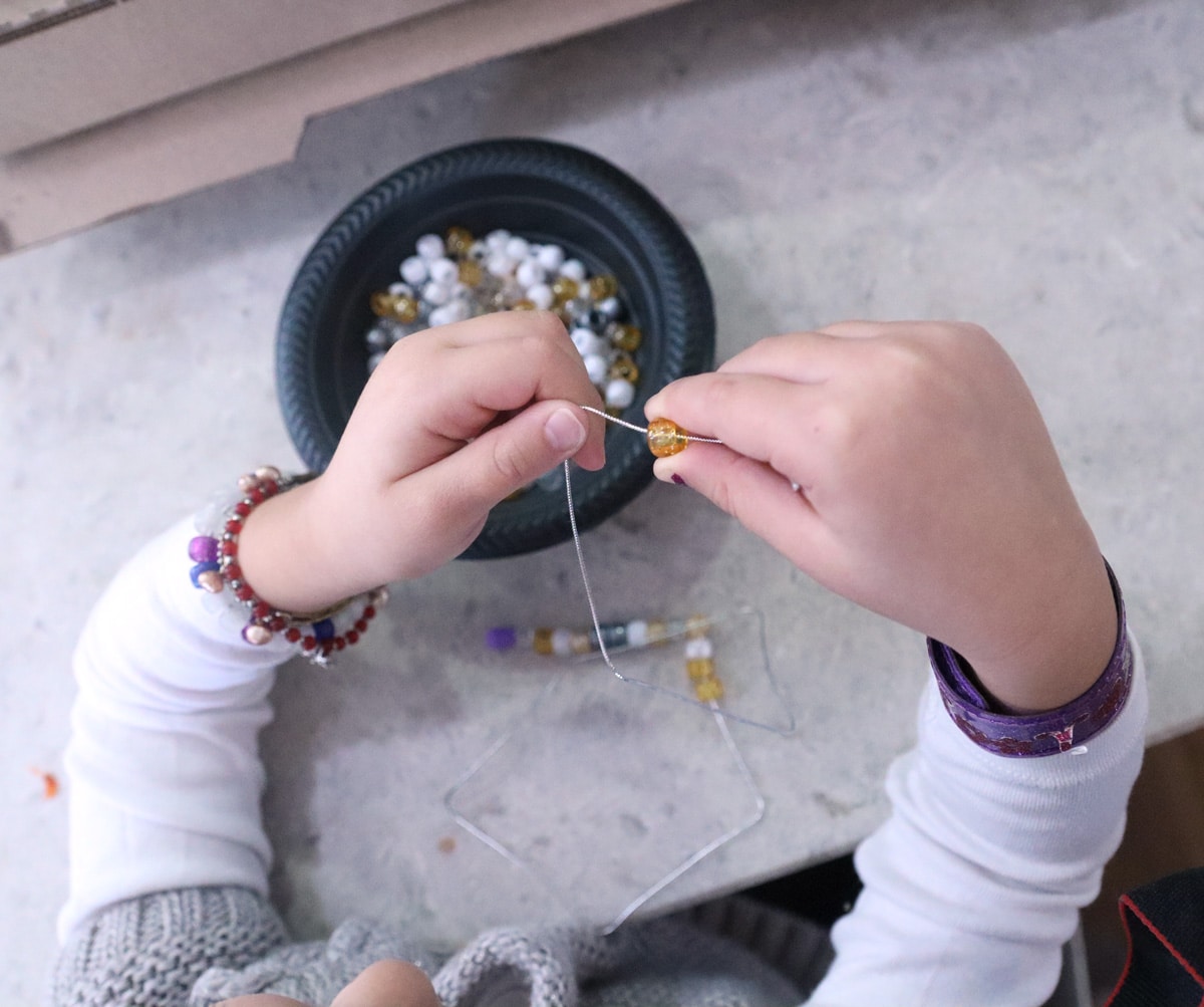 adding the beads to the necklace