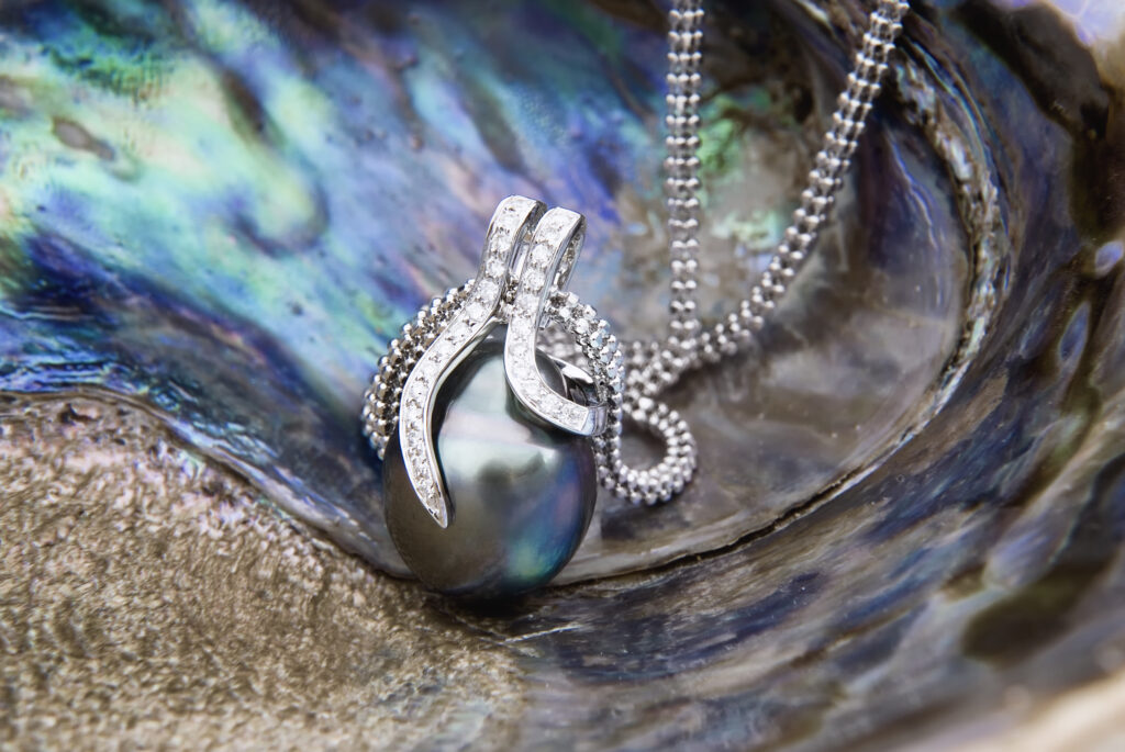A close-up of a white diamond necklace with a pearl