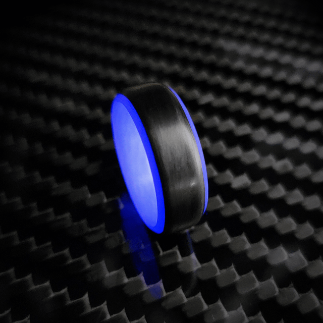 碳纤维环带有灰色室内设计，在黑暗中发光紫色