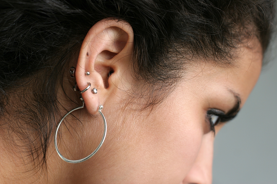 A white girl has five piercings in her right ear.