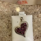 我在一次房地产拍卖会上购买了这款红榴石和石榴石银心形吊坠。看起来有些年头了……但从未穿过（仍在包装中）。底部和左侧有锈迹。这可以以某种方式调整吗？或者会损坏什么东西？