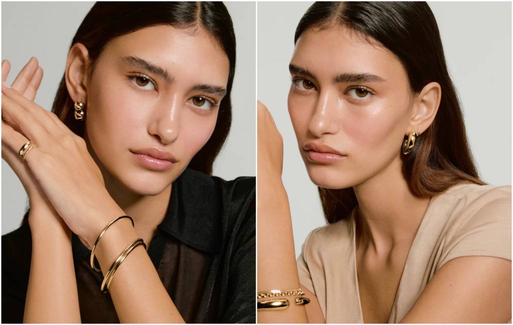 Split-image beauty/jewellery shot of a model with sleek centre-parted dark hair, wearing gold hoop earrings, layered gold rings, and stacked gold bangles/bracelets—left in a black top, right in a beige top.