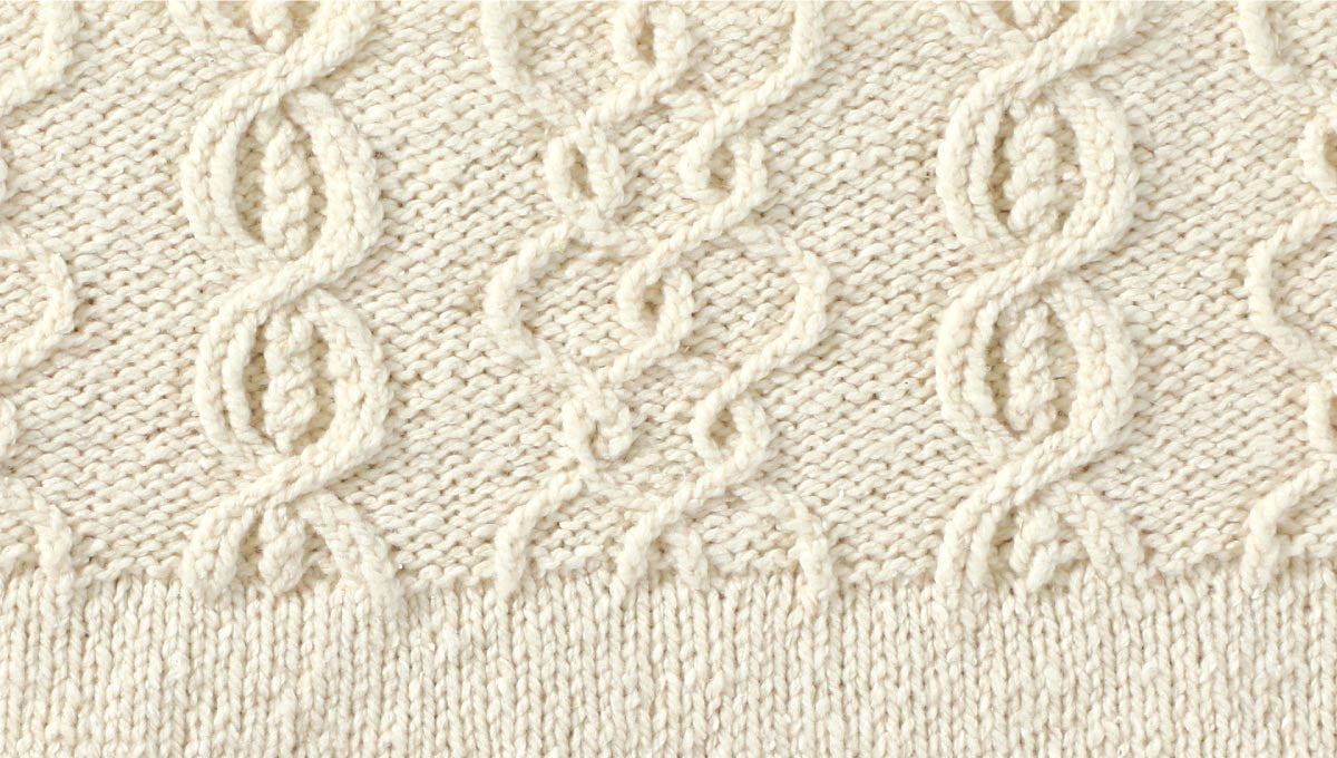 Detail of the Itinerant Pullover by Donna Estin, featuring twisted stitches.
