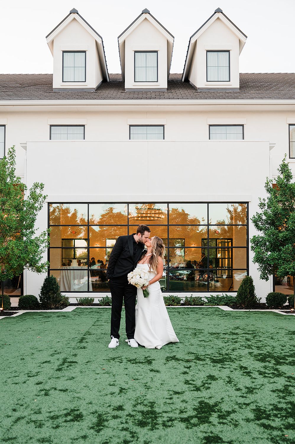 Newlyweds kissing outside wedding venue in Dripping Springs.