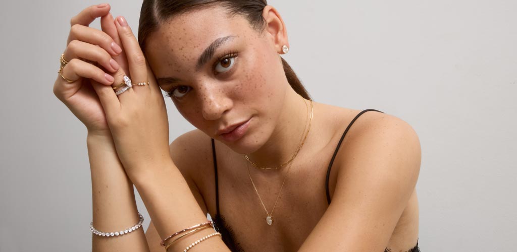 A model shows off necklaces, rings and earrings from the new James Allen Bezel Expansion Collection.